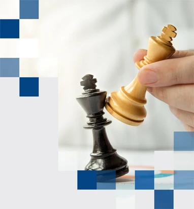 Pessoa movendo uma peça de xadrez branca sobre uma preta, representando estratégia e competição.